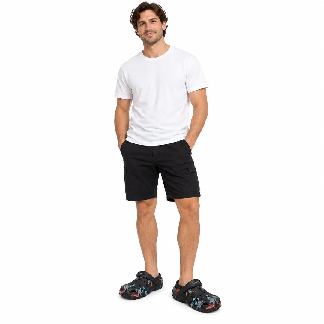 Full-length male model wearing Black graffiti garden clogs on a white studio background