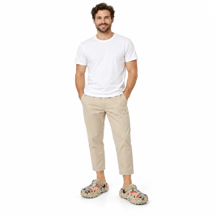 Full-length male model wearing Khaki graffiti garden clogs on a white studio background