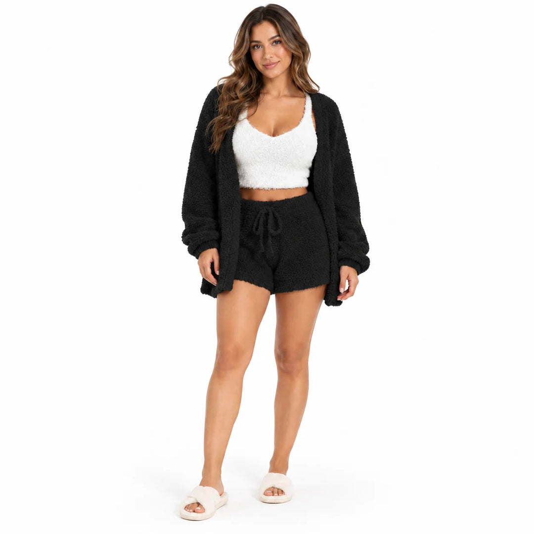 Full-body model in black lounge coat and drawstring shorts with a white cropped vest, front view on a plain white background.