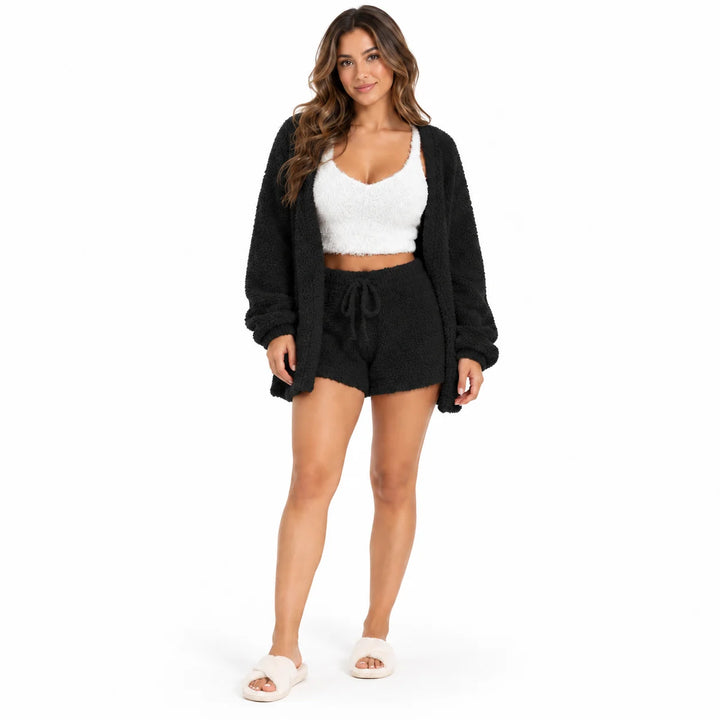 Full-body model in black lounge coat and drawstring shorts with a white cropped vest, front view on a plain white background.