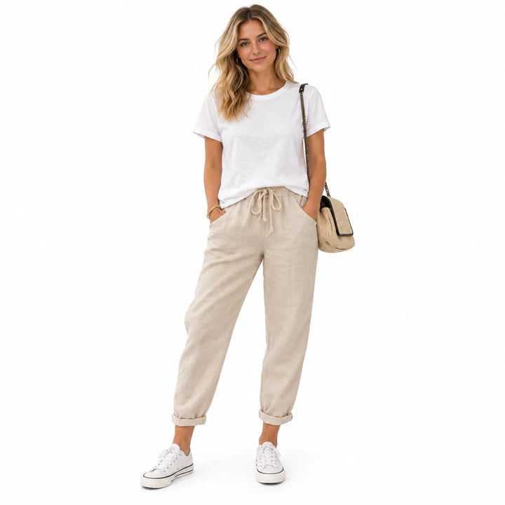 Khaki drawstring ankle pants on a standing adult woman, showing the ankle length and drawstring, on a plain white background.