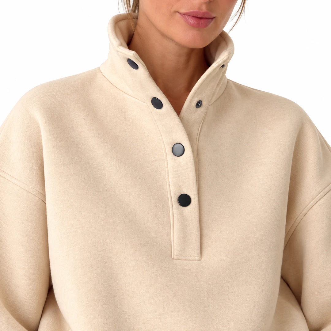 Close-up of the beige stand collar and dark buttons on the pullover, showing visible exterior details, on a white background.
