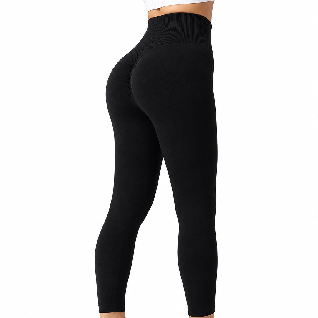 Black leggings shown from a ribbed waistband to the lower legs, revealing the gathered rear knit details on a white backdrop.