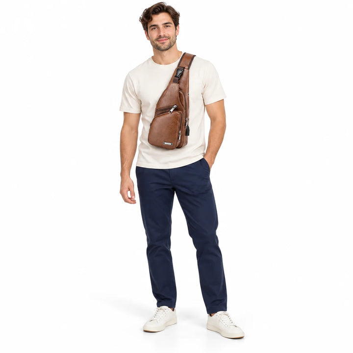 Full-body male model wearing the Light Brown sling bag across his chest, showing front zipped pockets against white backdrop.