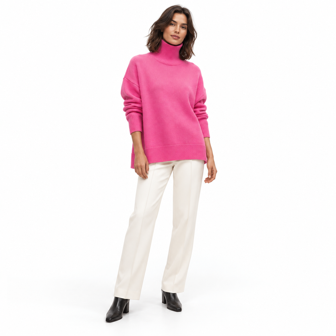 Full-length model wearing a rose red turtleneck sweater with ivory trousers and black ankle boots against a white background.