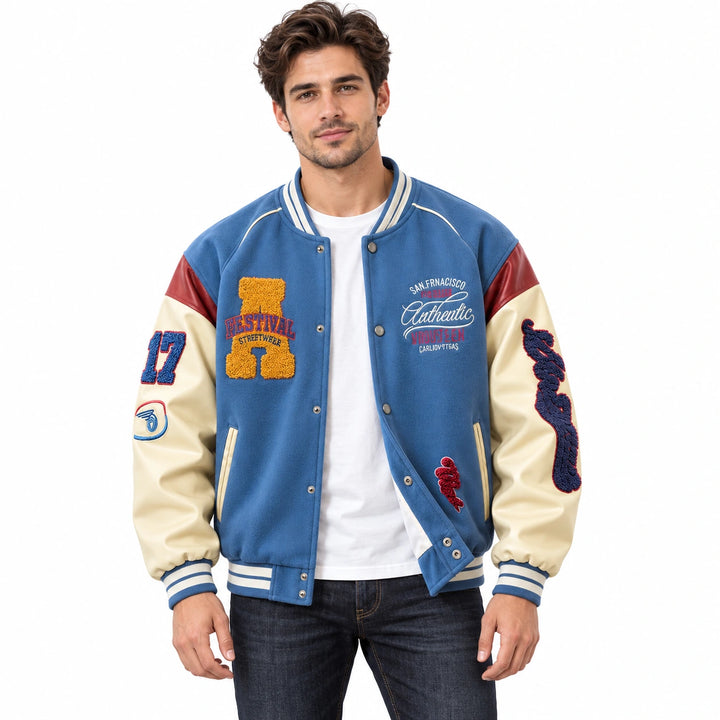 Male model wearing the Blue varsity jacket with cream sleeves and red shoulders over a white T-shirt and dark jeans.