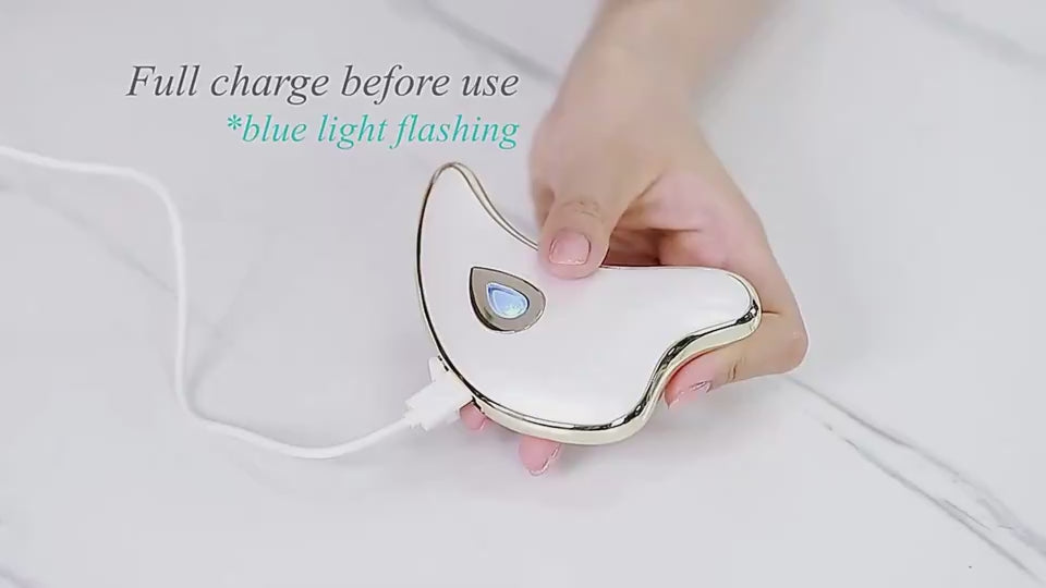Pink face and body massage tool shown close up on a white studio background with glossy finish, silver trim and power button.
