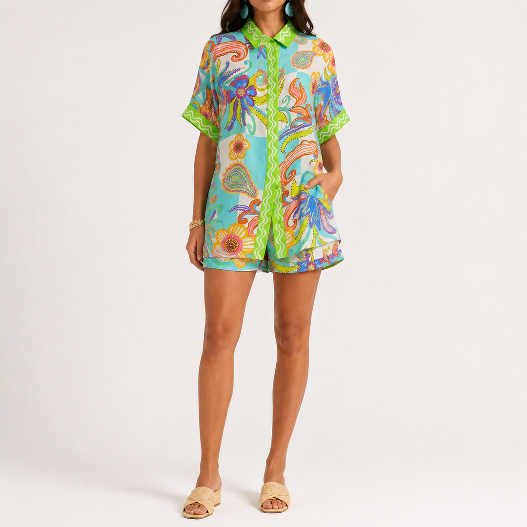 Printed button-down shirt and matching shorts set shown from the front, made from 100% polyester, with printed design detail.