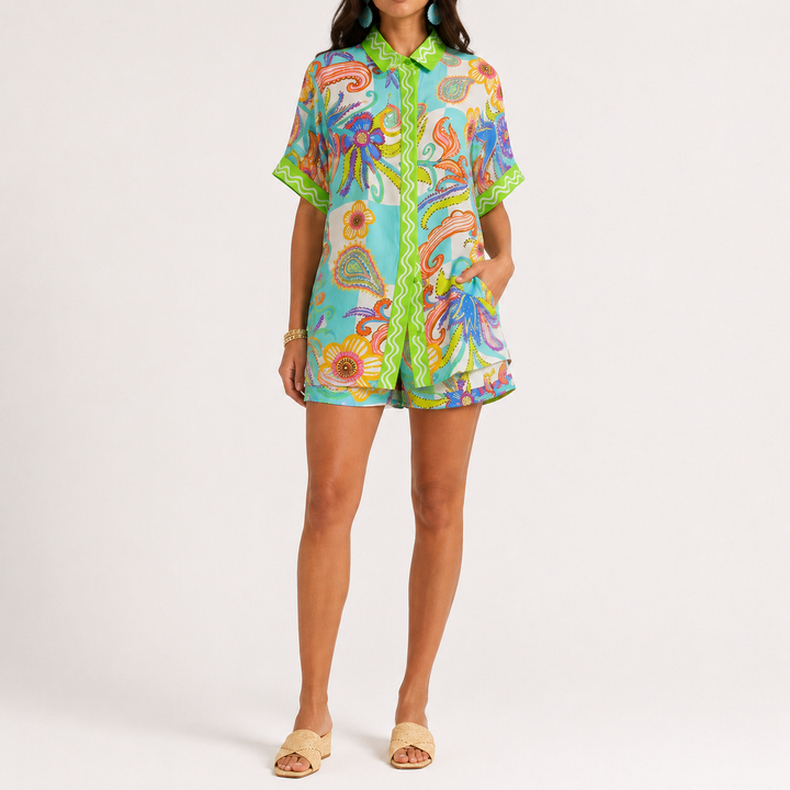 Printed button-down shirt and matching shorts set shown from the front, made from 100% polyester, with printed design detail.