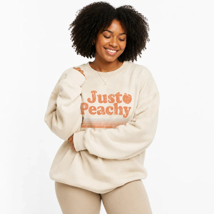 Cream printed sweatshirt for women in a cozy relaxed pose highlighting the oversized long sleeves.