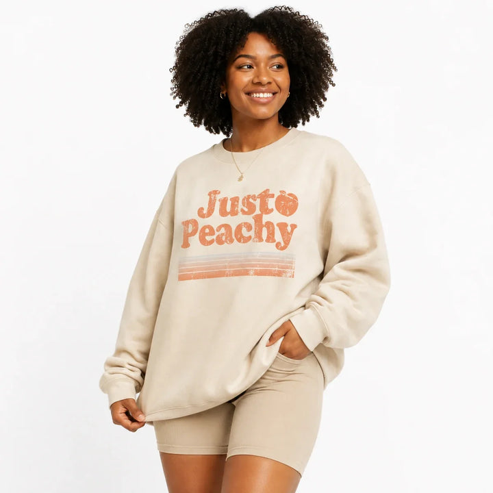 Cream printed sweatshirt for women in three-quarter view with Just Peachy graphic and relaxed fit.