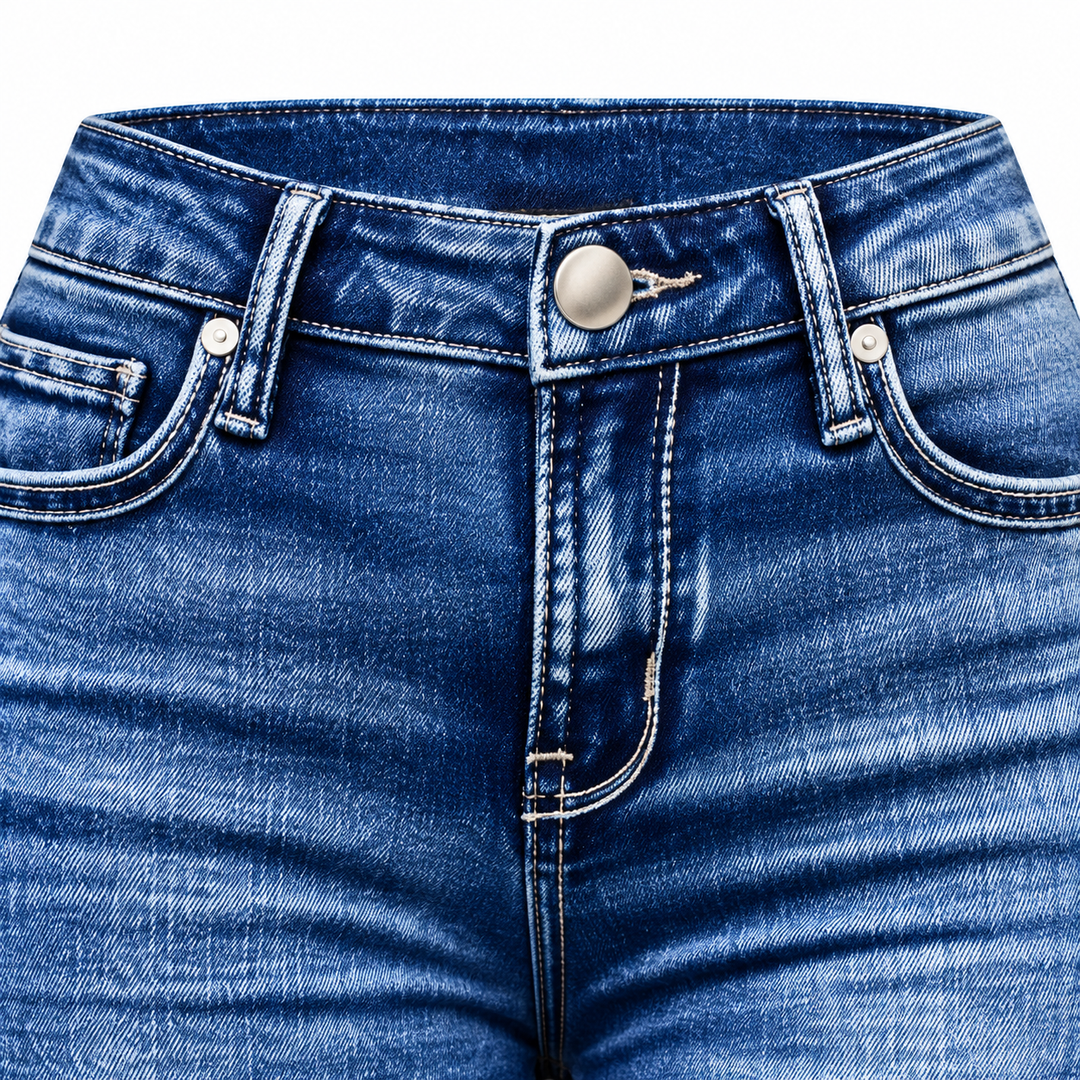Close-up of blue denim waistband, front pocket stitching and metal button.
