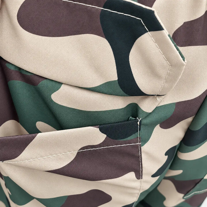 Close-up of Army Green Camouflage fabric, showing the green, beige and brown print, plain woven texture and pocket stitching.