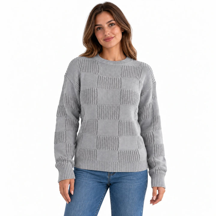 Front view of a model wearing the gray openwork checkerboard knit sweater