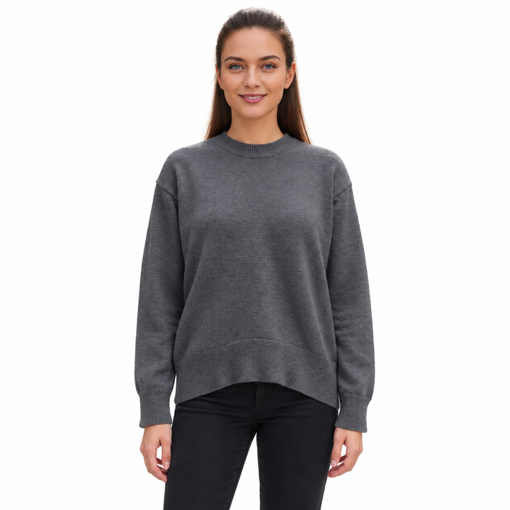 Dark Grey knitted pullover on a model against white, showing its crew neckline, long sleeves, relaxed shape and ribbed edges.