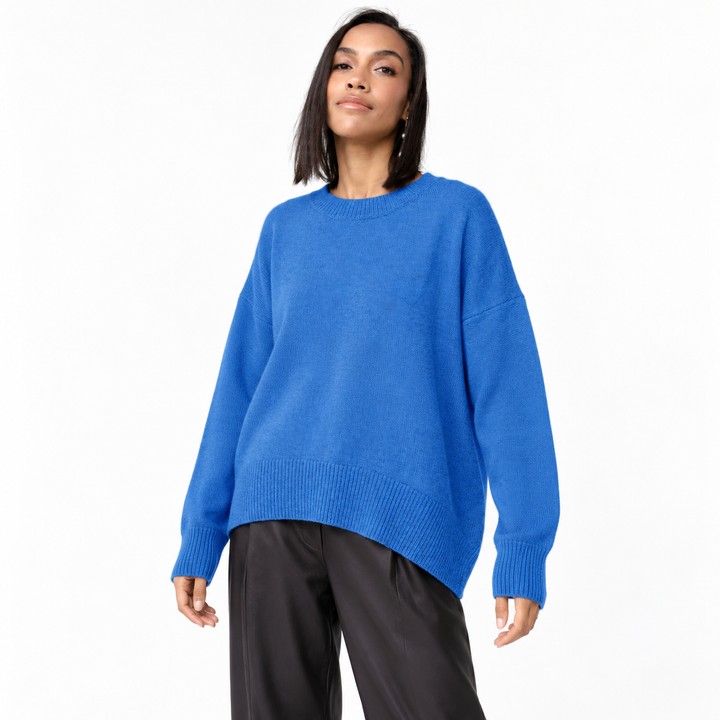 Sapphire Blue knit pullover on a model against white, with a crew neckline, dropped shoulders, long sleeves and ribbed edges.