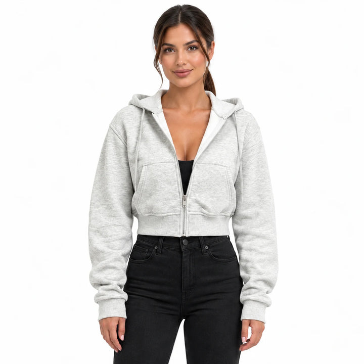Heather gray hooded sweatshirt on a model in an upper-body studio view, showing front pockets, long sleeves and a ribbed hem.
