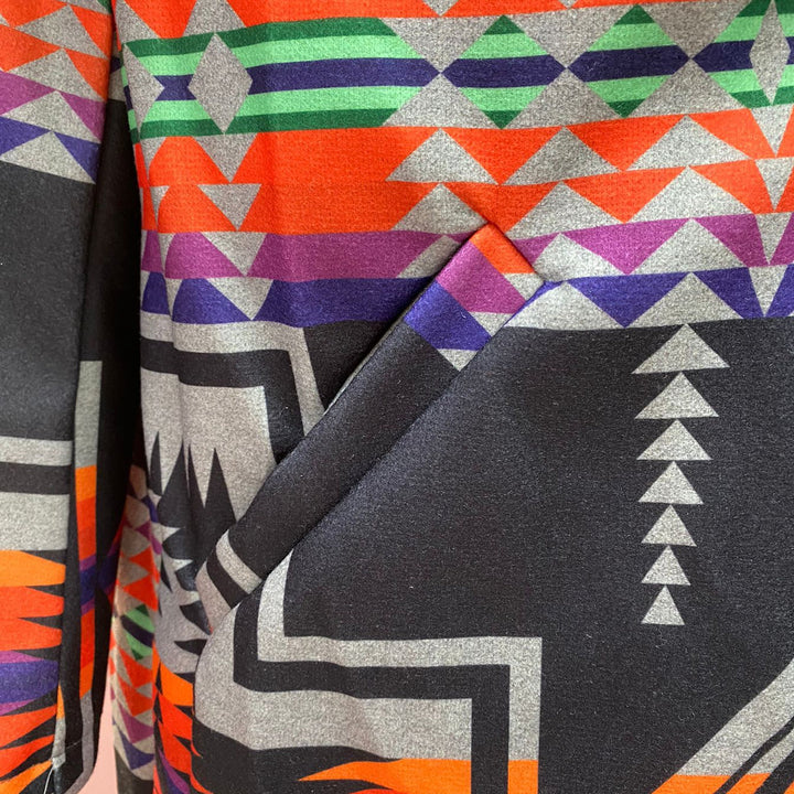 Original supplier close-up of the diagonal pocket and multicolor geometric print.