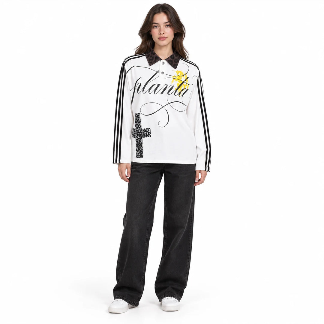 Adult female model wearing the White collared polo shirt with black sleeve stripes, cross print and a black patterned collar.