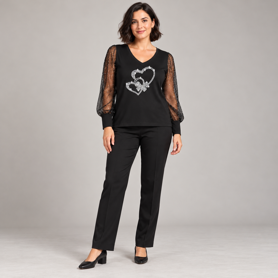Black V-neck top with intertwined outline hearts and sheer dotted sleeves on a full-length model