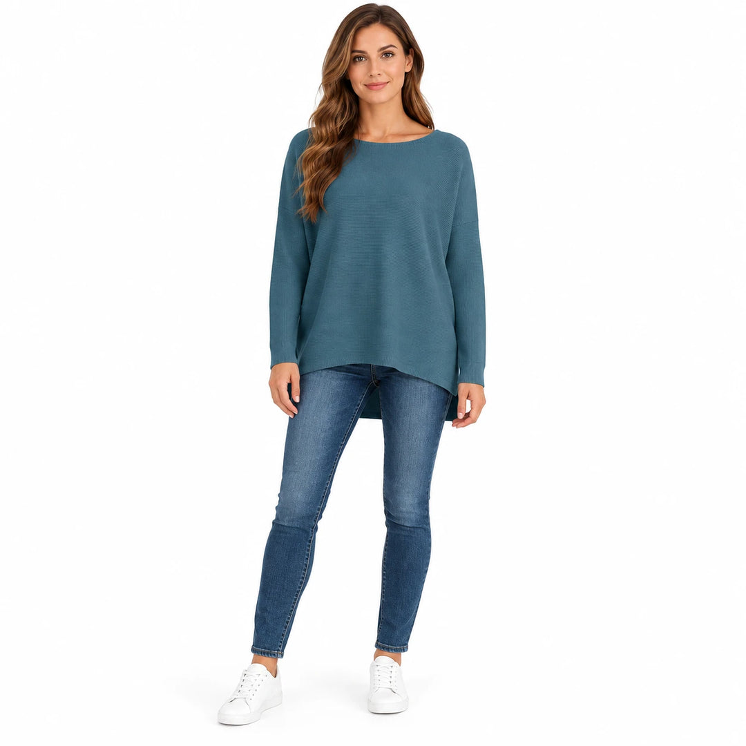 Adult woman wearing the Sea Blue batwing sleeve pullover, in a full-body studio view against a plain white studio background.