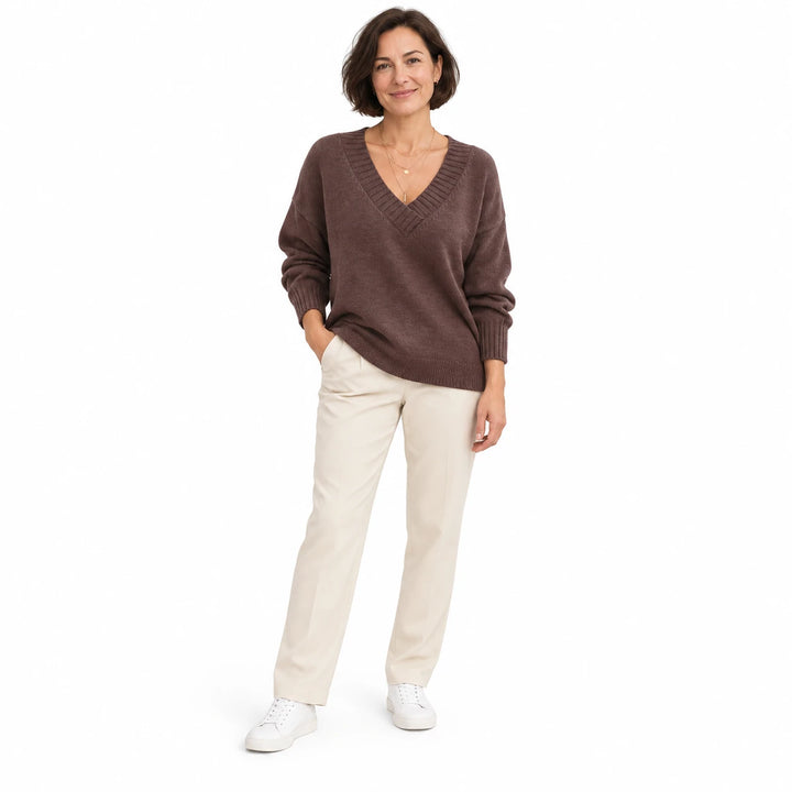 Short-haired adult woman wearing the Coffee V-neck knit pullover, in a full-body front view against a plain white background.