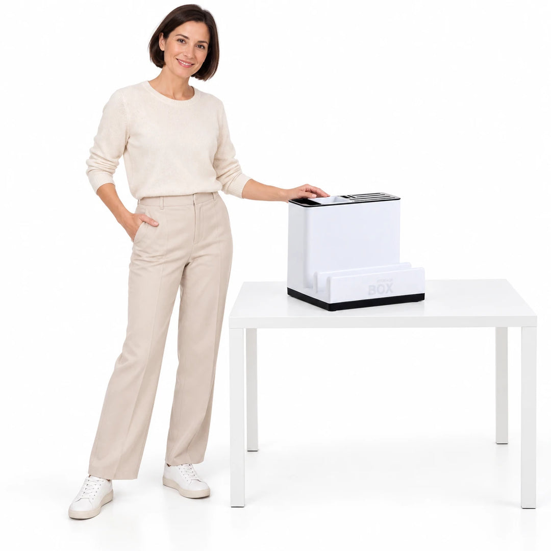 An adult woman beside the empty white plastic organizer on a white table, with the slots, raised front shelf and base visible
