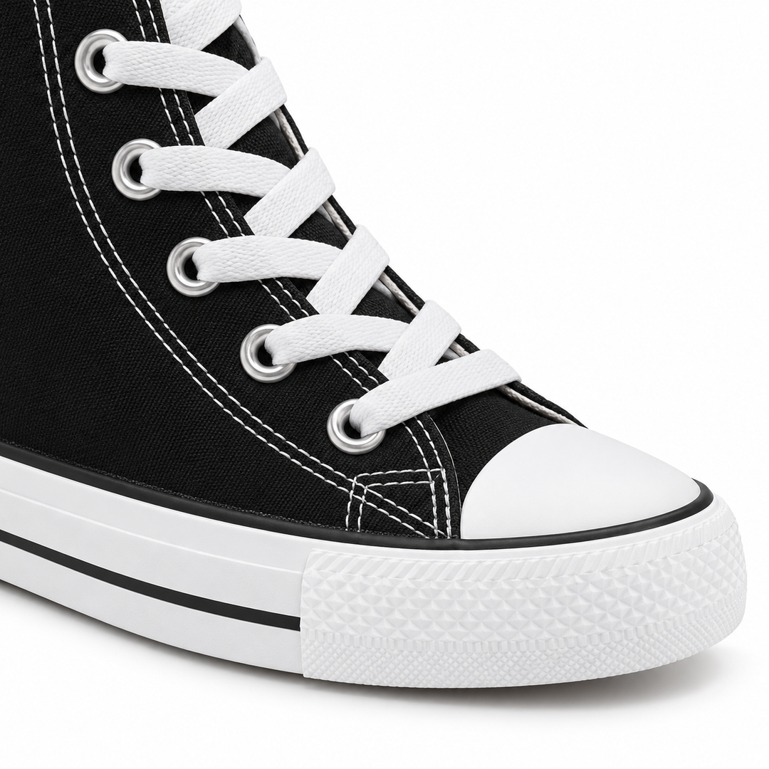Close-up of black high-top sneaker white laces, silver eyelets, white stitching and rubber toe