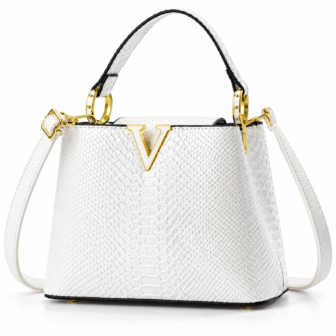 White PU handbag in a detailed front view with embossed scale texture and gold-tone V ornament against white studio backdrop.