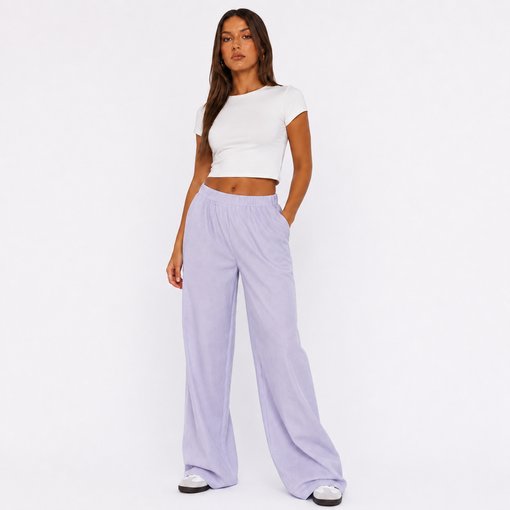 Purple wide leg pants for women on a studio model, showing elastic waist, soft drape and relaxed full-length Y2K silhouette.