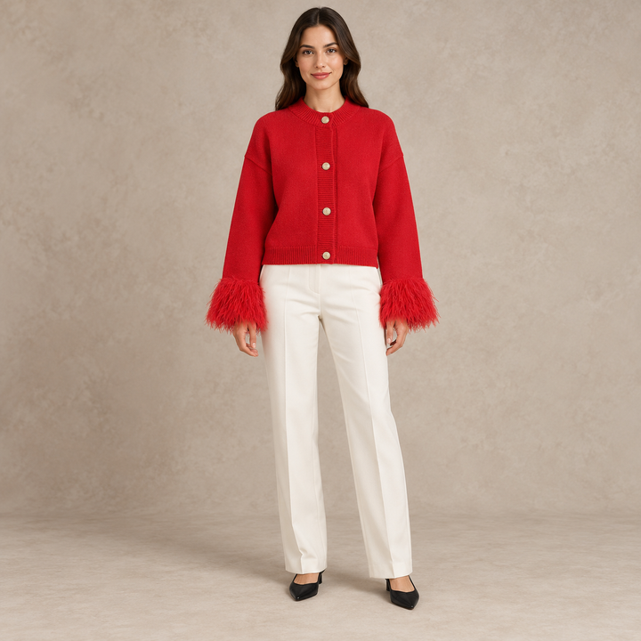 Full-body model wearing a red cardigan with feather cuffs and four gold-tone buttons in a taupe studio