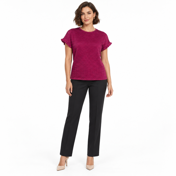 Oxblood red top on a brunette model with dark trousers, showing a round neckline, short sleeve ruffles and horizontal texture