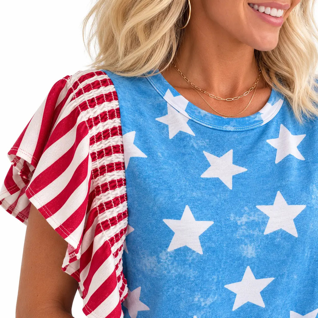Closeup of polyester top fabric with star print, visible stitching and striped gathered sleeve detail under soft studio light