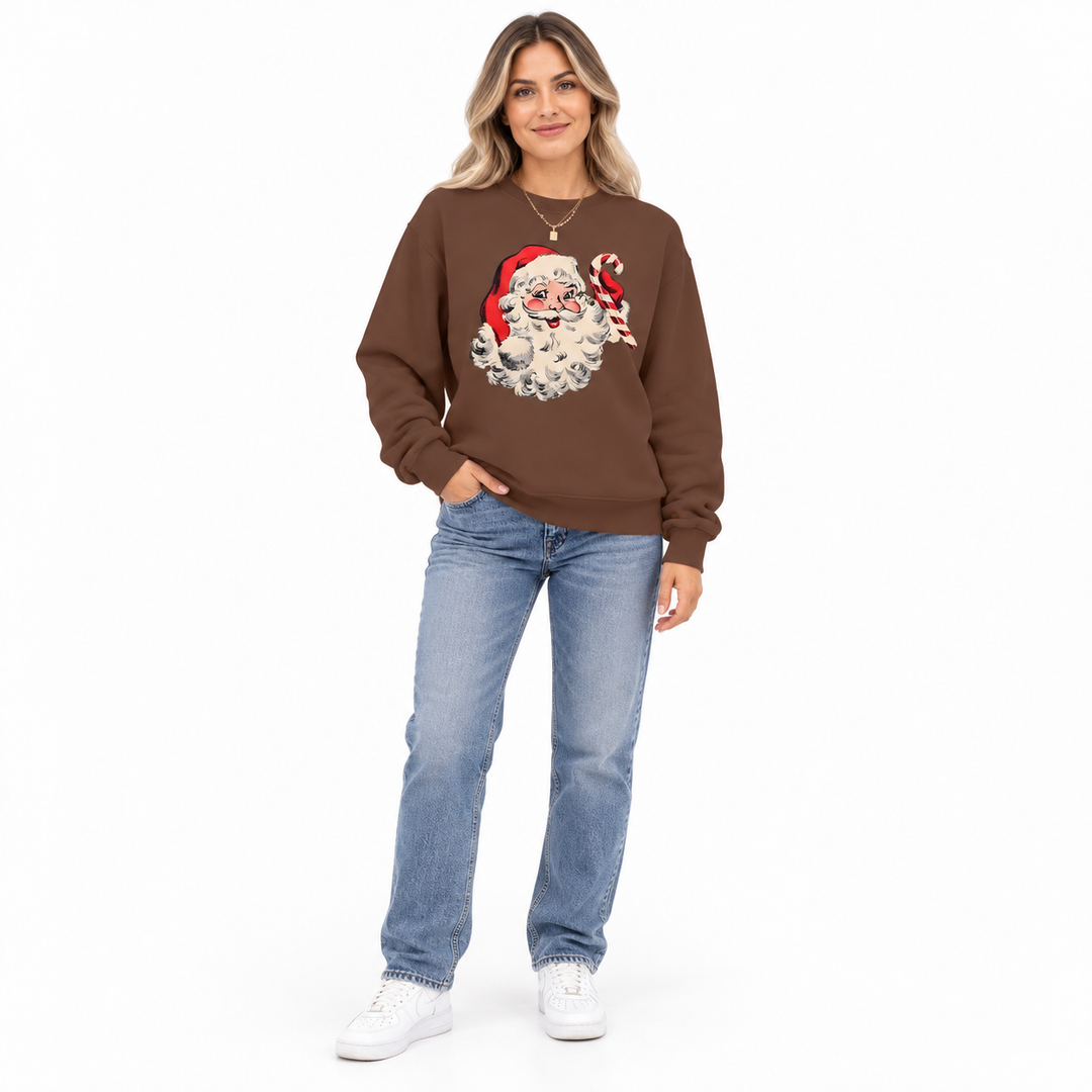 Woman modeling a coffee brown crewneck with Santa Claus &amp; candy cane print, blue jeans and sneakers against a white backdrop.