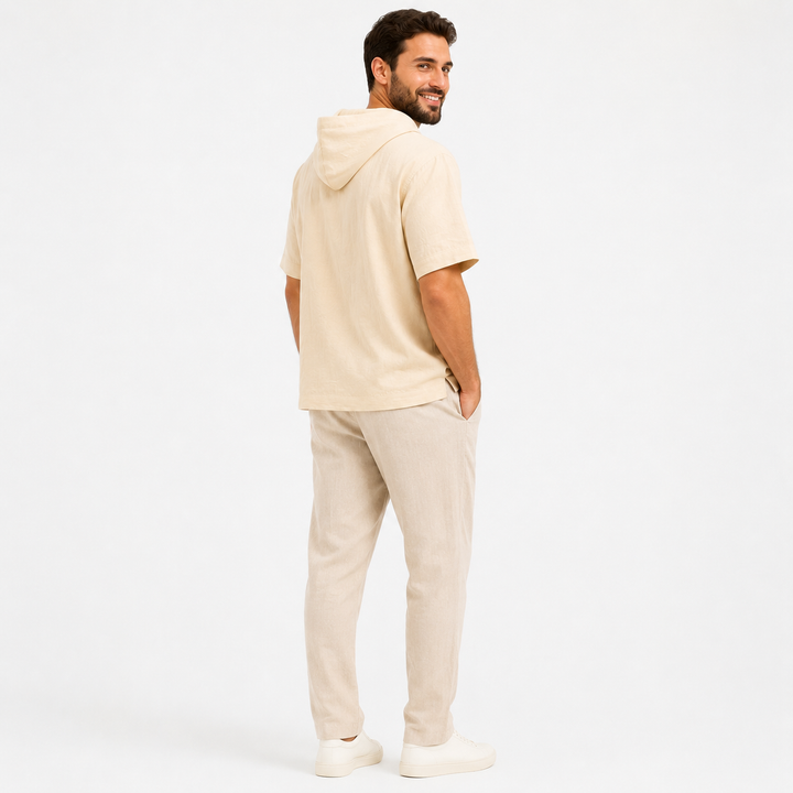 Man wearing an apricot short sleeve hoodie, rear view showing the hood and relaxed back drape.