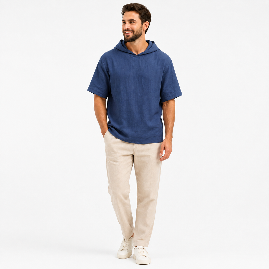 Man wearing a sapphire blue short sleeve pullover hoodie, full-body front view on a white background.