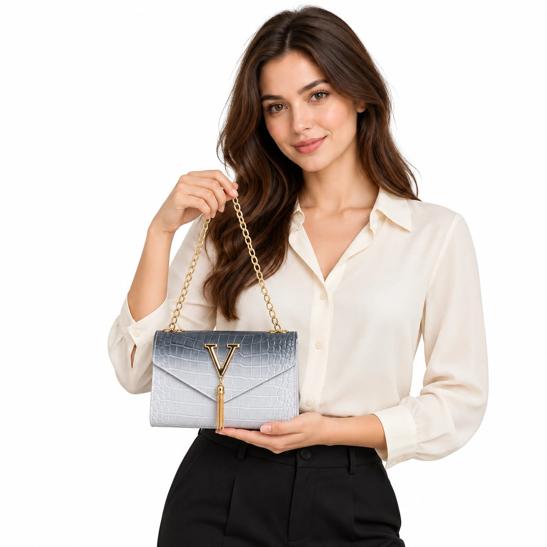 Woman presenting the black gradient chain shoulder bag with gold V and tassel