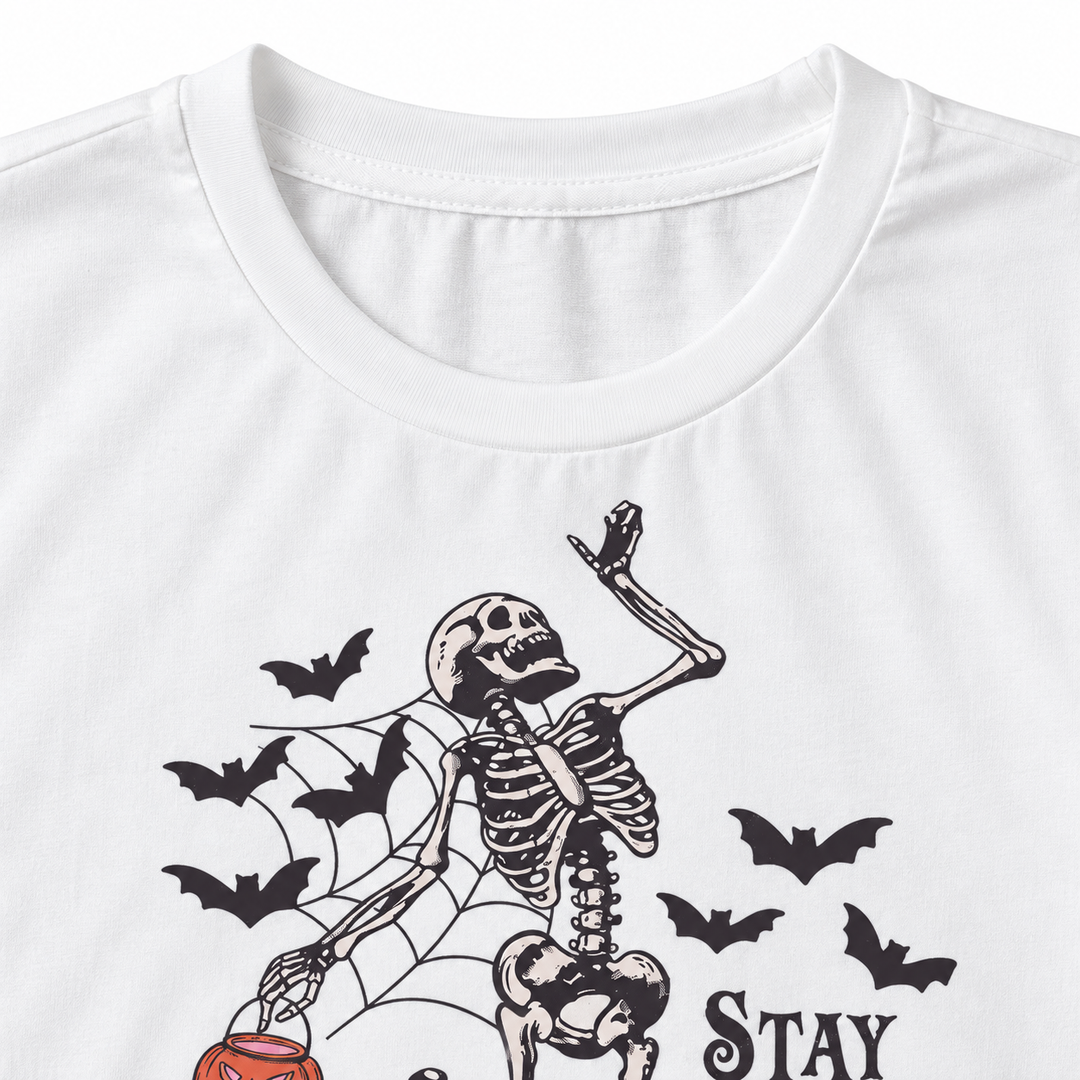 Close-up of white T-shirt neckline with skeleton bats and spiderweb print detail