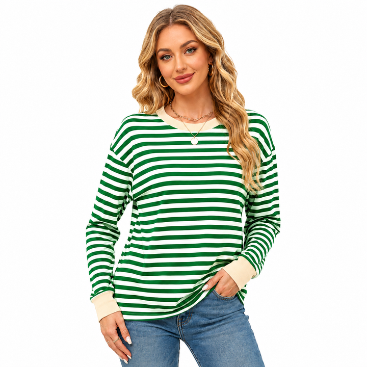 Striped long sleeve top for women in green and white stripes with beige neckline and cuffs, modeled with blue jeans on white.