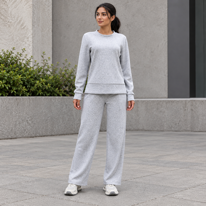 Full-body model wearing a light gray crewneck sweatshirt and matching straight-leg pants.