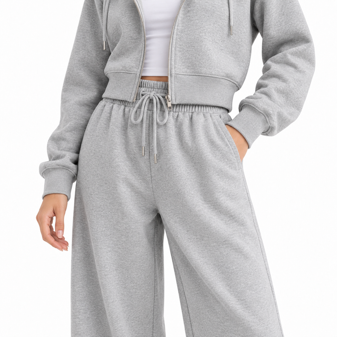 Close-up of gray tracksuit showing drawstring waistband, side pocket, zipper and fabric detail