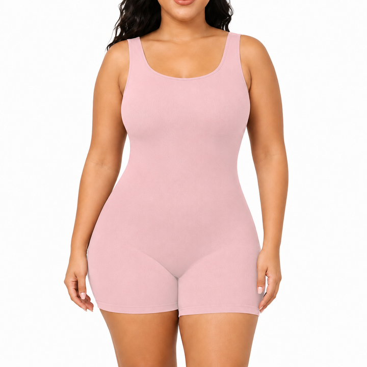 Pink shapewear bodysuit front view on a model showing scoop neckline, wide straps, smooth body and mid-thigh shorts on white.