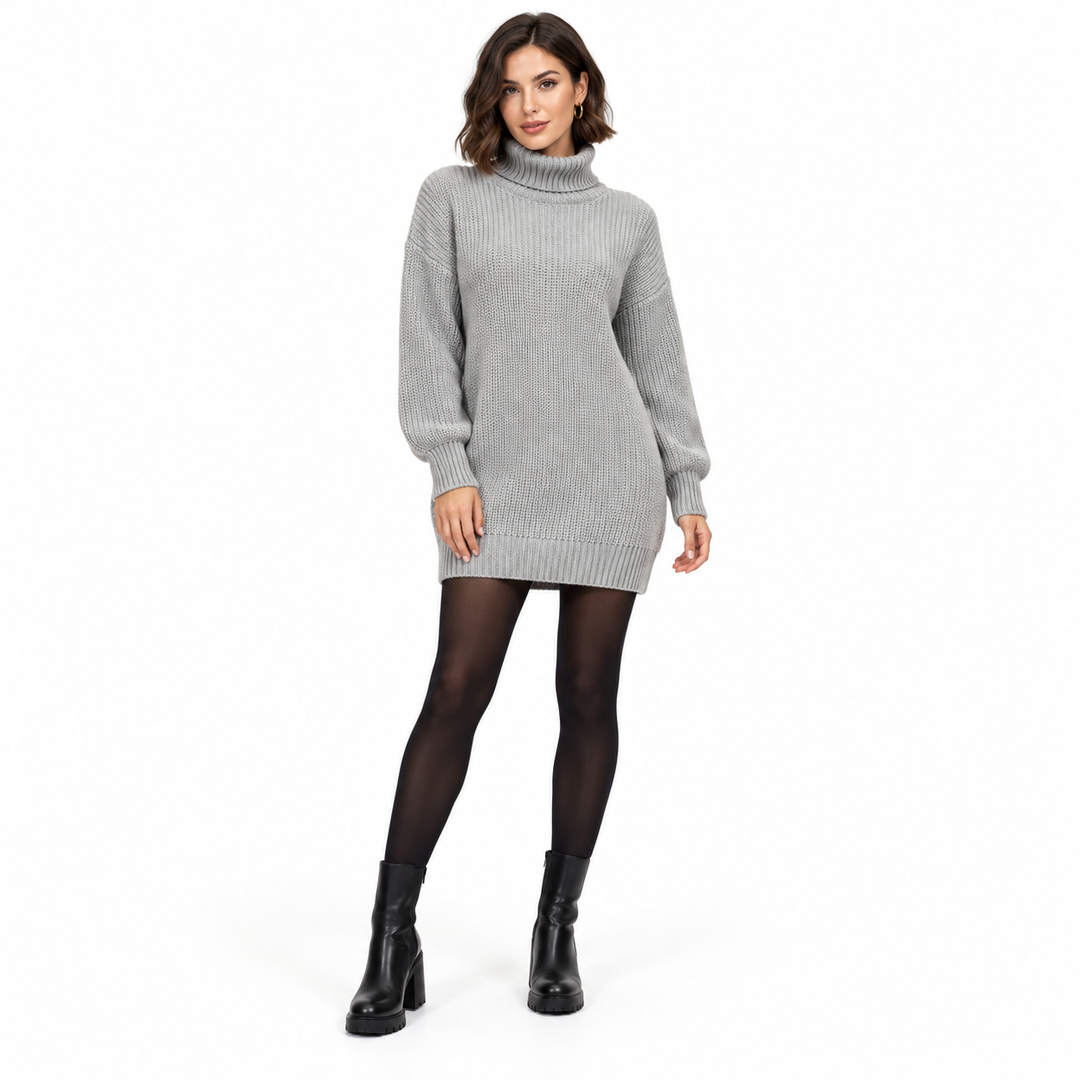 Another adult model wearing the gray knit dress with a short brunette hairstyle, black tights and ankle boots on a white set.