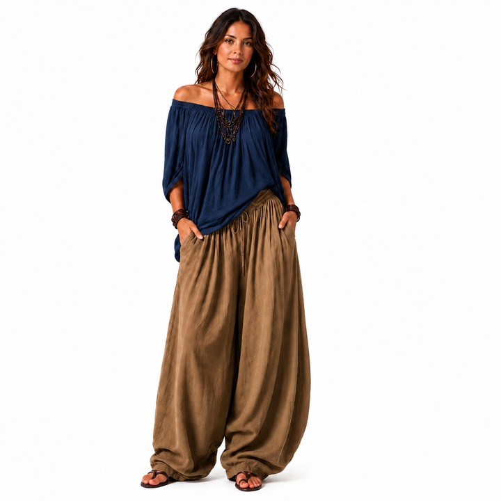Woman wearing a navy blue off-shoulder top and khaki gathered pants, full-body view on a clean white background.