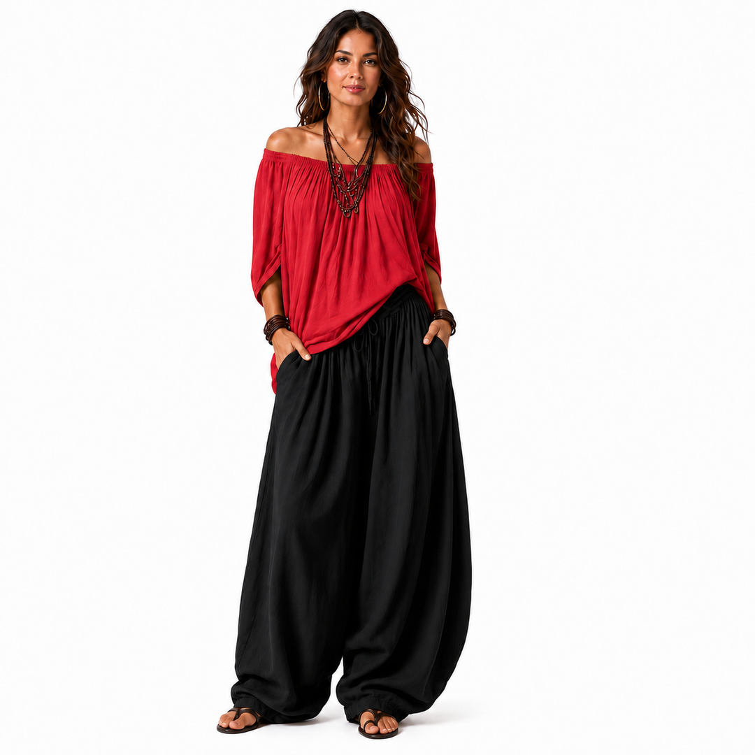 Woman wearing a red off-shoulder top and black gathered pants, full outfit shown on a clean white background.