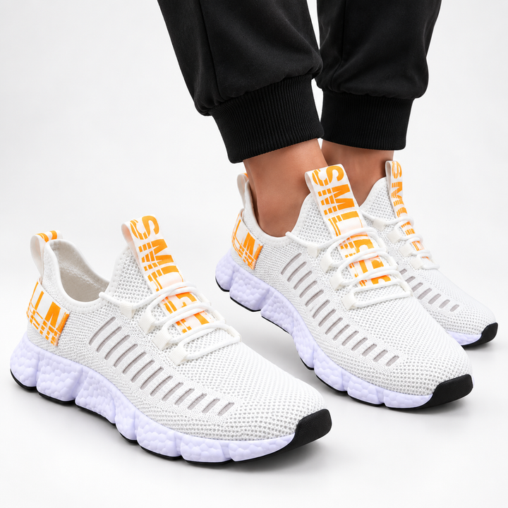 Ivory orange casual sneakers shown in a clean studio composition with mesh texture, round toe, cross-strap lacing and segmented sole.