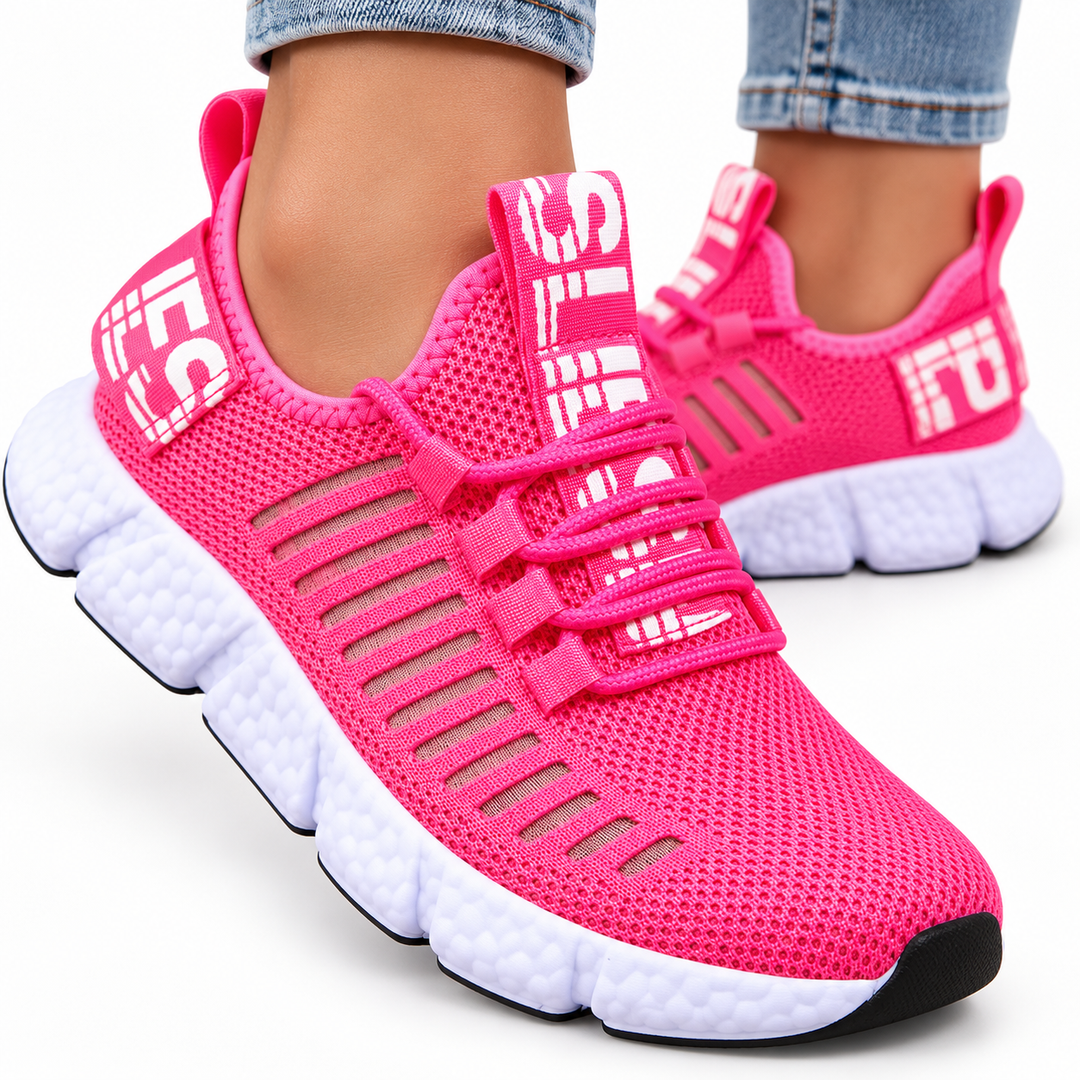 Rose pink casual sneakers in a close studio view showing mesh texture, round toe, cross-strap lacing and segmented white sole.