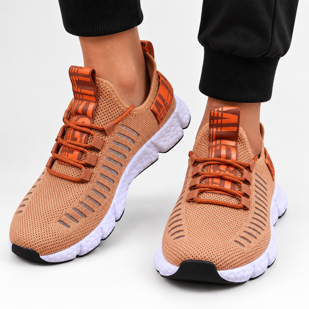 Warm tan casual sneakers in a front studio view showing mesh texture, round toe, cross-strap lacing and segmented white sole.