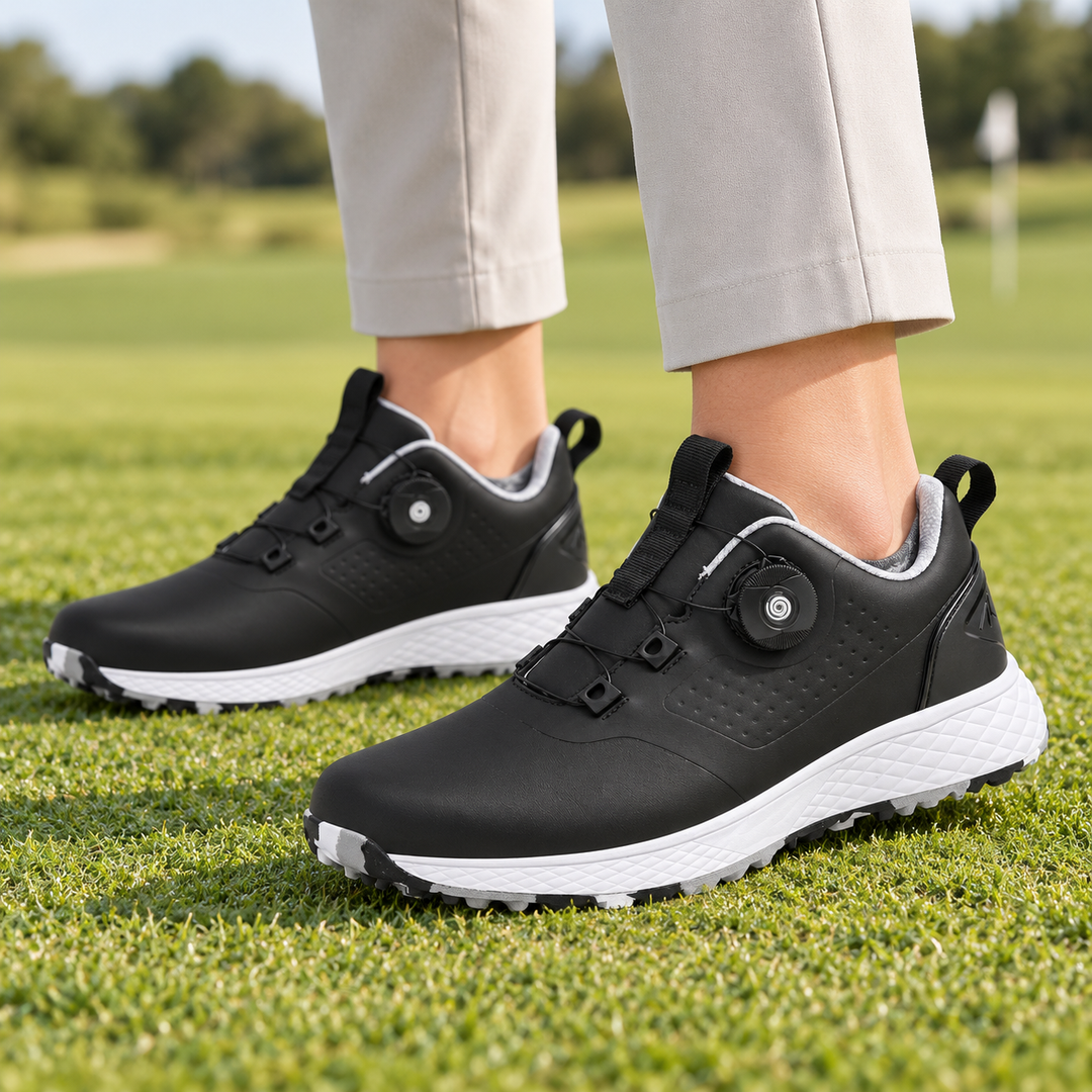 Black rotary buckle footwear worn with light trousers on grass, revealing the black side dial, white midsole and gray lining.