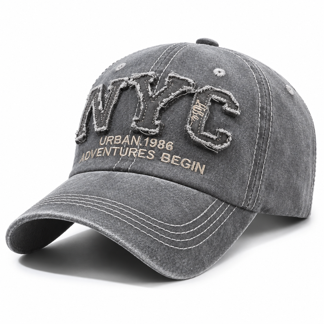 Gray adjustable NYC baseball cap shown alone on white with curved brim, washed finish and detailed embroidered front stitching.